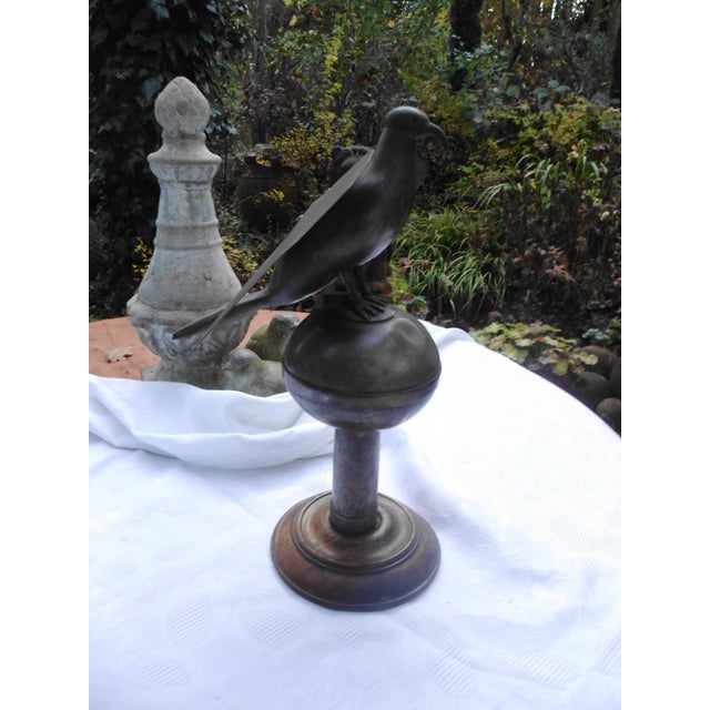 Antique metal bird sculpture on a round wooden base with a beautiful patina. It is likely a unique piece. There are some...