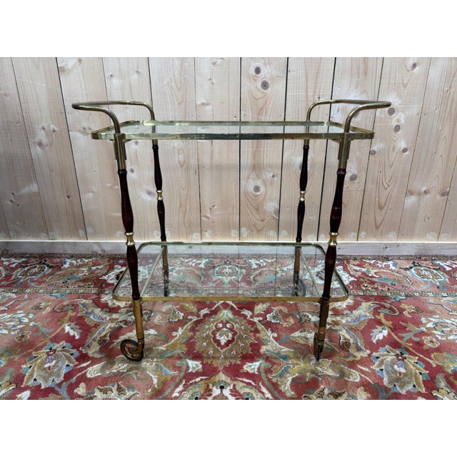 An elegant vintage serving cart from the 1950s-1960s with timeless charm. This rolling table embodies the refinement of...