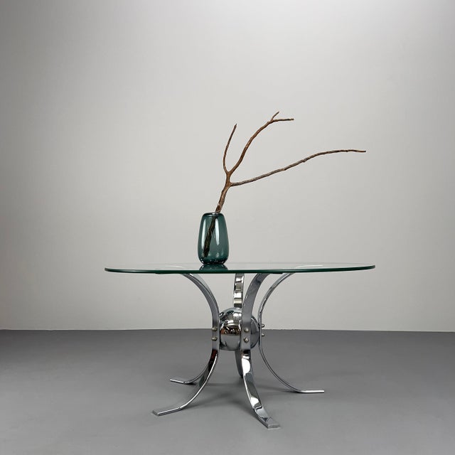 Striking space-age coffee table with chrome-plated frame and round glass top.