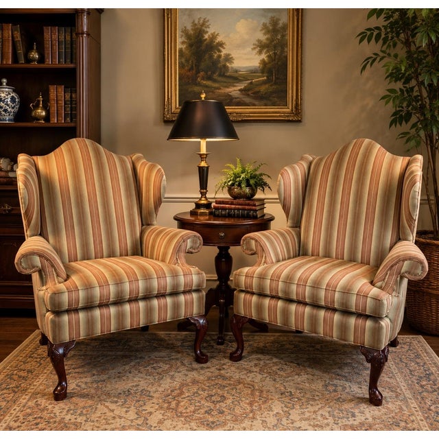 A handsome pair of vintage Queen Anne style wingback club chairs showcasing timeless traditional design and exceptional...
