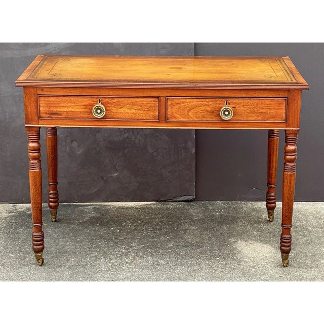 A fine English writing table or desk of mahogany from the late 19th century, featuring an inset embossed leather top, with...