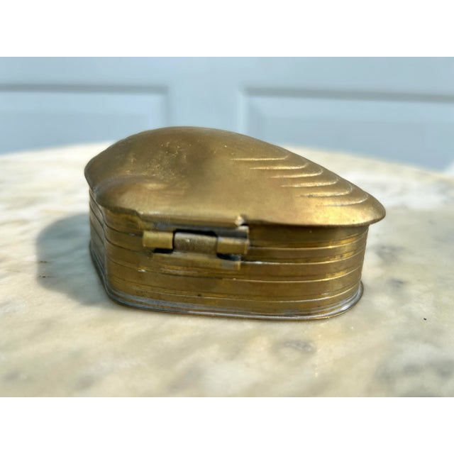 A collectible brass mollusk with a hinged top shell shaped lid for small items like rings, earrings, hair ties, etc. This...