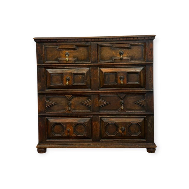 This solid wood chest of drawers features classic Jacobean style geometric molded panels across four tiers of drawer...