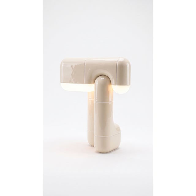 A table lamp that behaves like sculpture. Its folded, tile-built form reads as one continuous gesture, and when the light...
