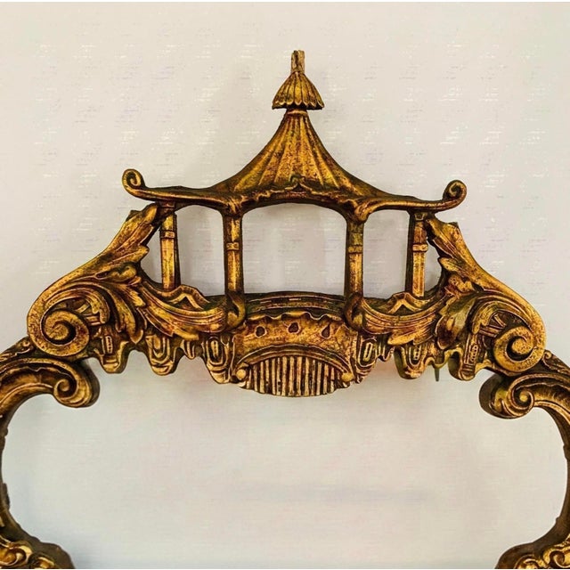 An ornate, vintage Chippendale style giltwood wall mirror featuring a pagoda top crest and figural bird accents along the...