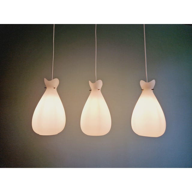 Set of scandinavian pendant lights from the 60s in white satin glass with 3 brass branches. the shape of the upper collar...