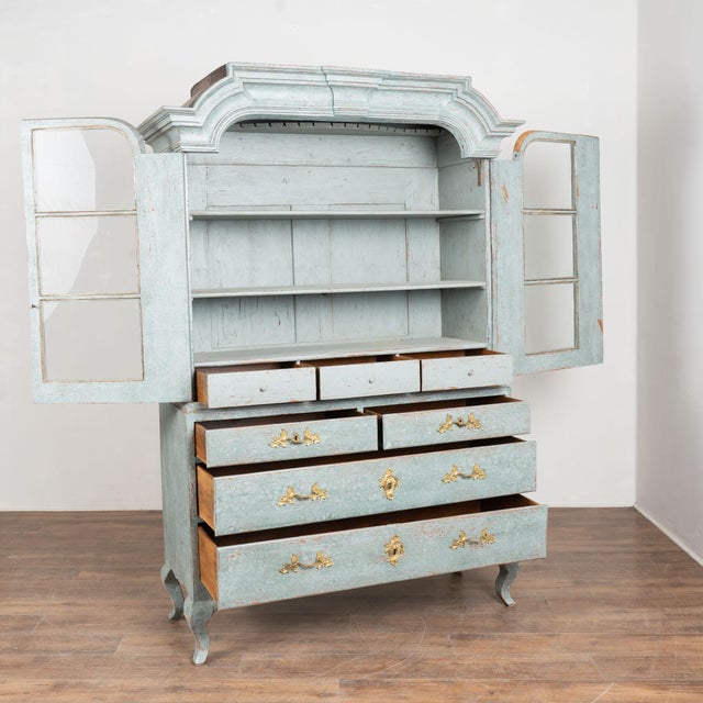 Early 19th century Swedish display cabinet, crafted in pine. The cabinet has a newer, layered professional blue painted...