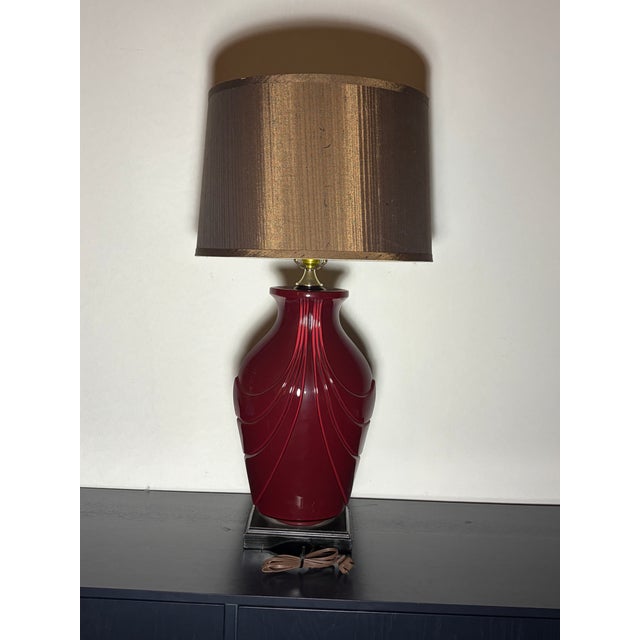 Show stopper high glam lamp from the 1980s. Dark berry red with brass swag detailing. Wired and working.