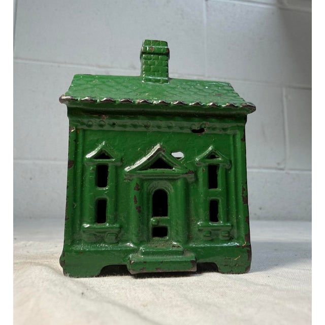 The Antique 1927 cast iron house shaped still bank by Andy & Susan Moore is a unique and original collectible piece...