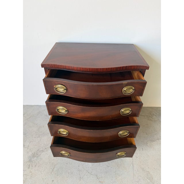 Elegant 1970s Heritage Henredon bow front nightstand crafted in rich mahogany with a beautifully figured top accented by a...