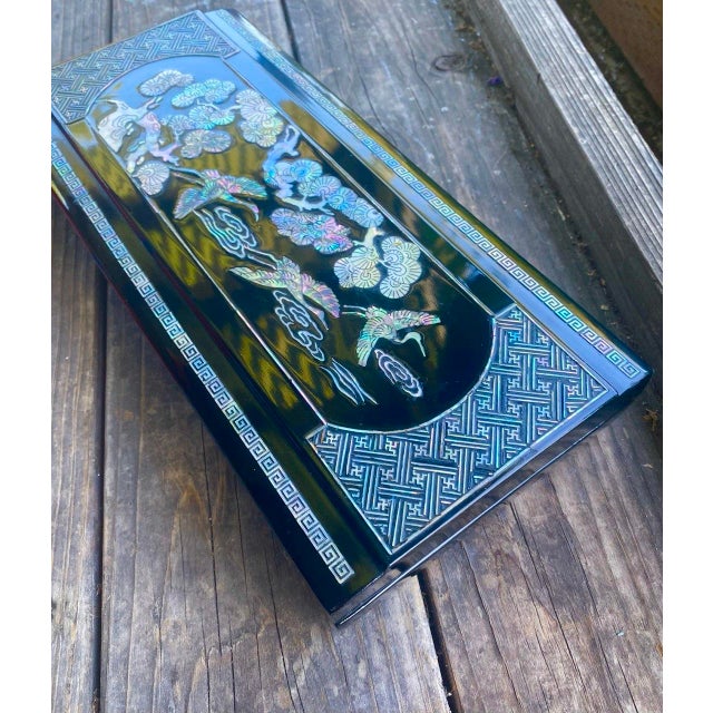 A striking vintage Korean black lacquer presentation or scholar’s box featuring exceptionally detailed hand-cut mother-of-...