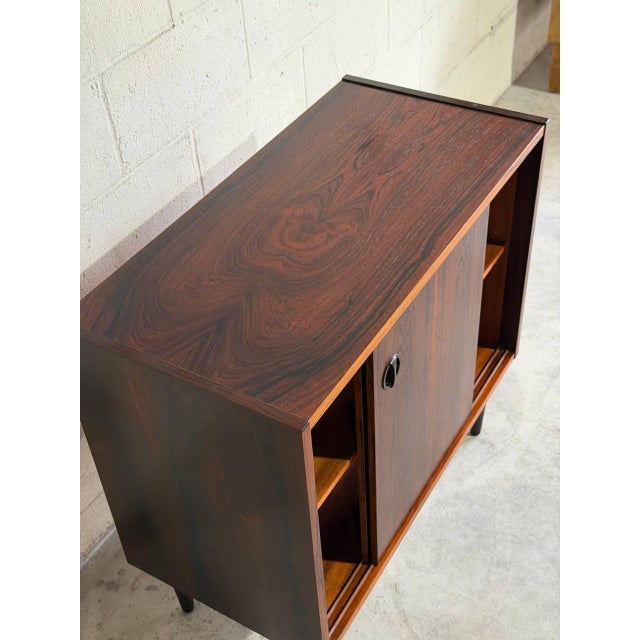 Beautiful vintage Danish mid century cabinet crafted in richly grained rosewood veneer with elegant tapered legs and...