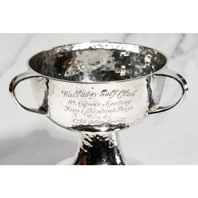A superb example of English Arts & Crafts silversmithing, this antique hammered sterling silver trophy cup combines...