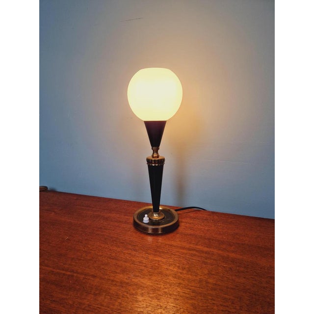 Table lamp in black lacquered metal, brass and white satin glass globe, 1950s The lamp has been completely re-electrified,...