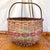 A large American hand-woven oak splint gathering basket with a bent oak handle. Red and green painted decoration on front...
