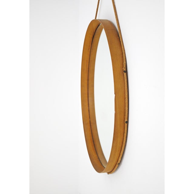 Large round wall mirror from the 1950s and 1960s. The deep circular frame is made of fine curved wood. The distinctive...