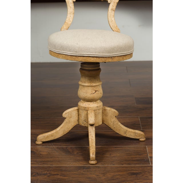An Austrian Biedermeier bleached burled walnut swivel chair from the mid-19th century, with new upholstery. Born in...