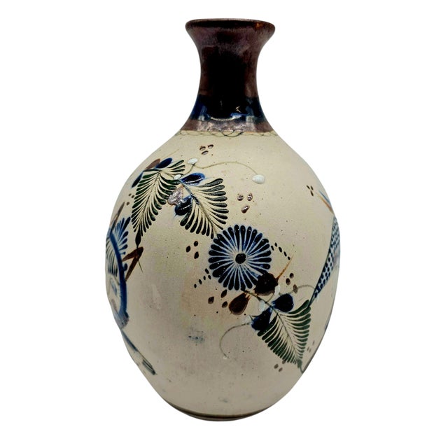 In this vessel, myth breathes. Crafted in Tonalá, this signed pottery vase tells a tale in earth tones and cobalt. A...