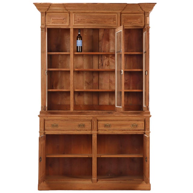 A handsome Belgian two-part cabinet crafted in solid pine, dating to circa 1900. This architectural case piece features a...