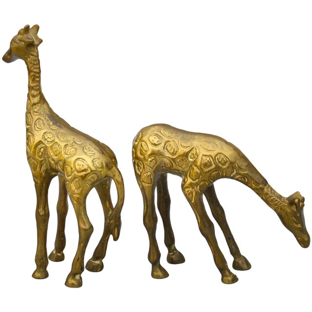 Beautiful and heavy vintage pair of giraffes, meticulously handcrafted of solid brass, and well-made in ornate playful and...