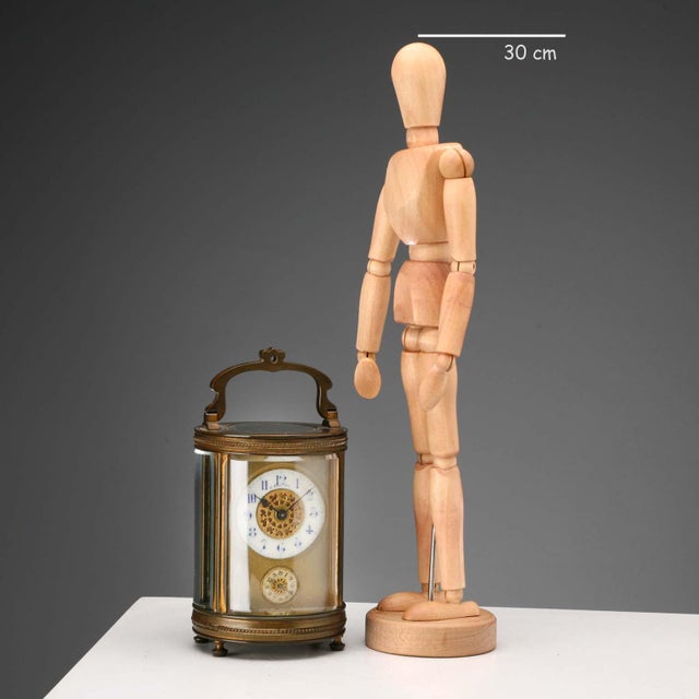 Travel clock in bronze and beveled glass. Visible movement. Dial signed P. Bagliani with Arabic numerals for hours and...