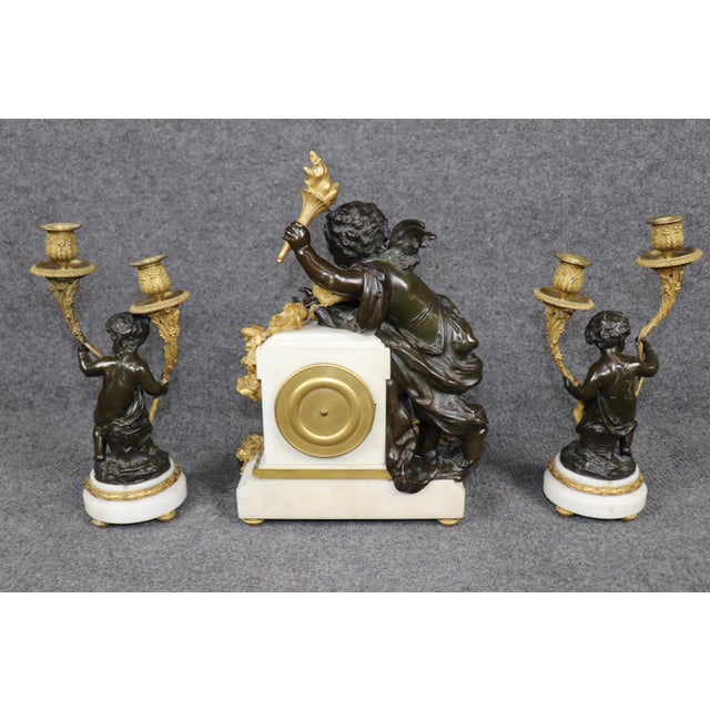 This exquisite three-piece French bronze and marble clock garniture by Lemerle-Charpentierwith a movement by Samuel Marti...
