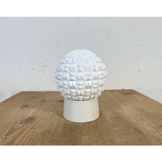 Vintage industrial ceiling or wall light made in former Czechoslivakia during the 1970s. It features a white porcelain...