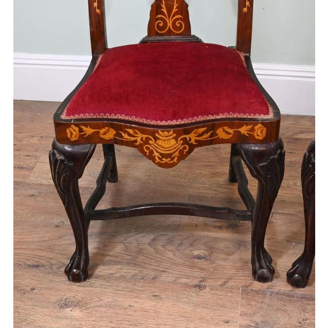 A decorative pair of Dutch style side chairs with elaborate floral marquetry in contrasting light woods The tall shaped...