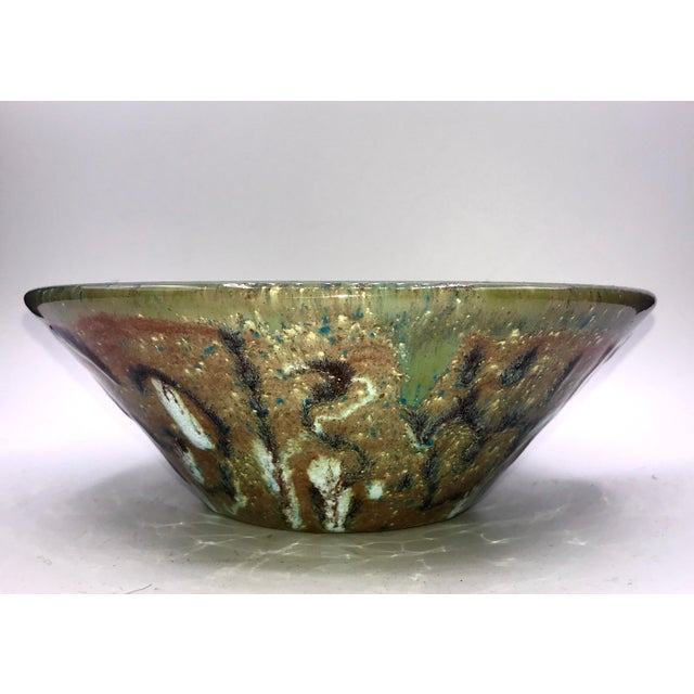This bowl is wild. The clay is gritty and its texture shows through as speckled. The glaze on the inside has interspersed...