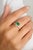This elegant ring features a modern octagon-cut emerald set east-west, complemented by an octagon-cut diamond. The vibrant...