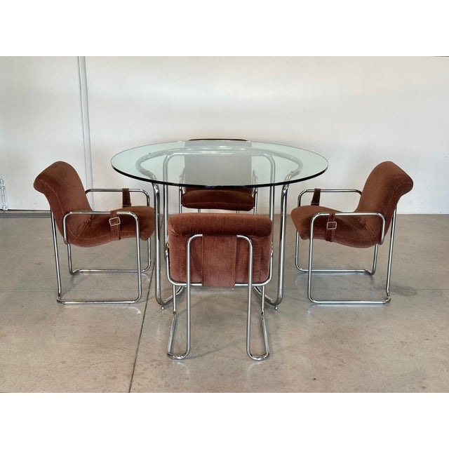 1970s dining set by Guido Faleschini consisting of a round table in chromed steel and glass top (119 cm. diameter X 76 cm....