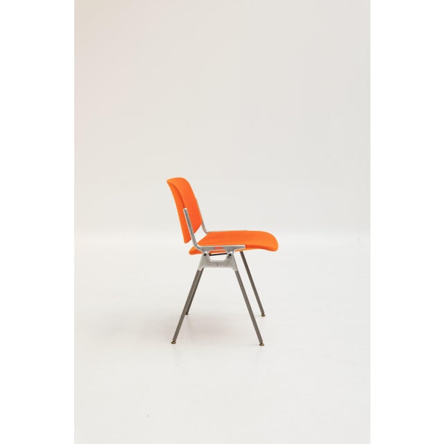 DSC 106 chair designed by Giancarlo Piretti in 1965 and produced by Castelli. This iconic model features an orange fabric...