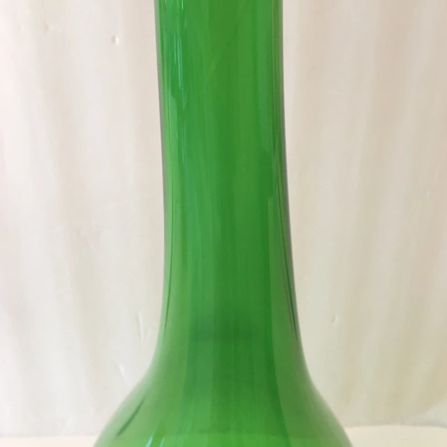 Wonderful handblown tall green glass bottle. The beauty of it's natural way of being blown makes it wonderful to look at...