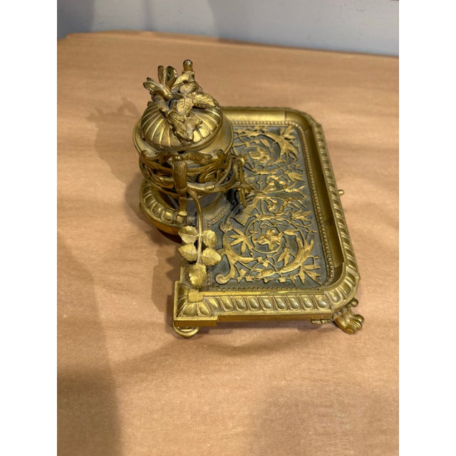 This is a beautiful antique inkwell & stand. It is brass with ornate details. It is French in a rococo style. It would be...