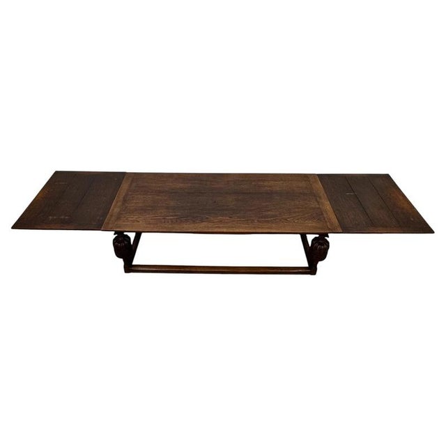 An exceptional and monumental 19th-century English draw-leaf dining table, finely crafted from oak and extending to an...