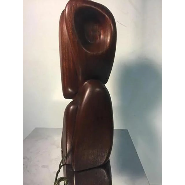 A beautiful and sculptural carved exotic wood table lamp, illegibly signed, circa 1960.