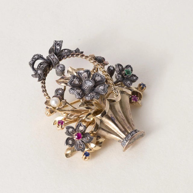 This is a Victorian brooch featuring a basket of floral gemstones, diamonds and pearls Circa 1890 Details: The center...