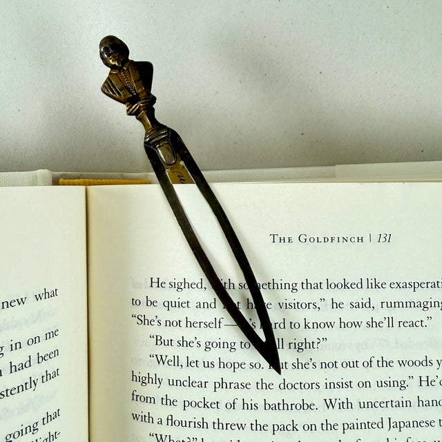 A brass letter knife or bookmark, made by George Unite, Birmingham, England, date marked 1902. The head of William...