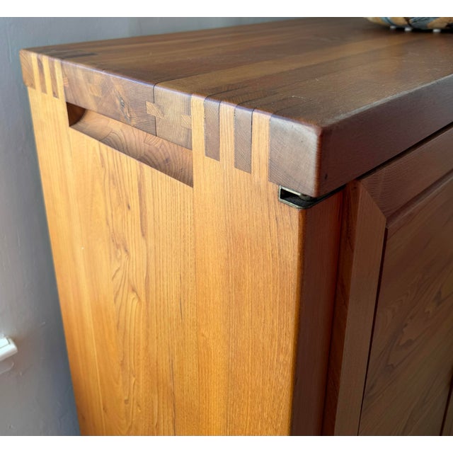 Solid elm cabinet in excellent condition. The front features two asymmetrical doors and drawers, thoughtfully structured...
