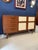 Teak sideboard with ivory vinyl-covered doors. Typical Italian light-colored interior and glass shelf. Four drawers.
