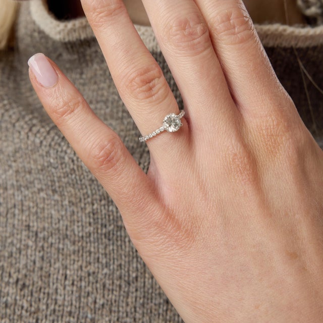 A timeless expression of brilliance and refinement, this vintage pavé ring centers on a 0.76 carat round brilliant diamond...