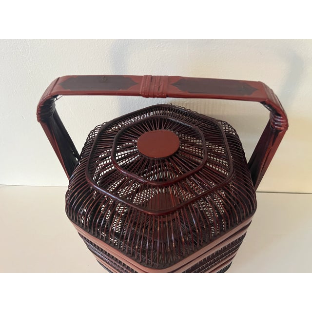An antique Chinese handmade openwork wedding/food basket made in red-stained bamboo with red lacquer, dating between...