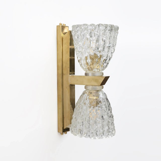A pair of Art Deco-style wall lamps, featuring a double bowl in hand-blown Murano glass, and a brass frame. These highly...