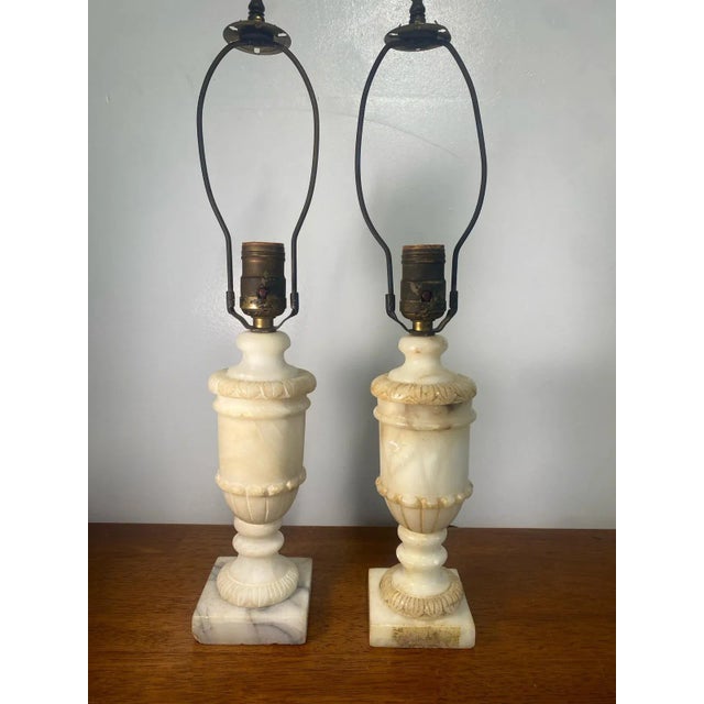 This elegant pair of table lamps features genuine alabaster marble urn bases crafted in Romania, showcasing classic...