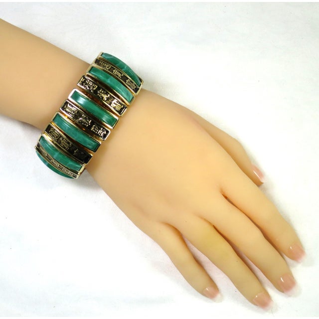 1950s Designer Harwood gold-plated expansion bracelet. Panels etched with Chinese characters alternate with curved Lucite...