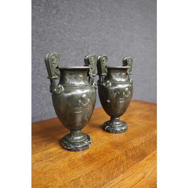 Exceptional pair of Italian Neoclassical bronze Grand Tour urns, each raised on a circular black marble base. The...