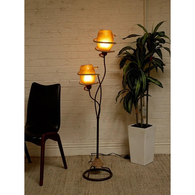 A fantastic vintage Atomic Age floor lamp featuring two glowing textured shades suspended at staggered heights along a...