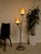 A fantastic vintage Atomic Age floor lamp featuring two glowing textured shades suspended at staggered heights along a...