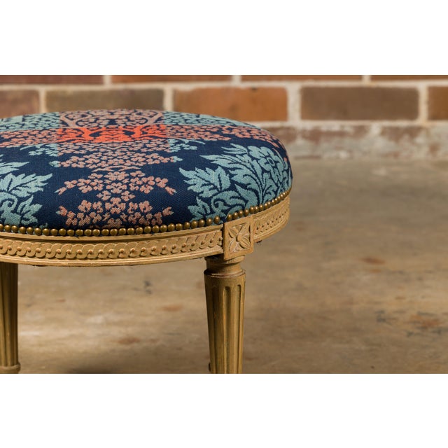 A French Neoclassical style painted stool from circa 1920 with circular upholstered seat, guilloche carved apron and...