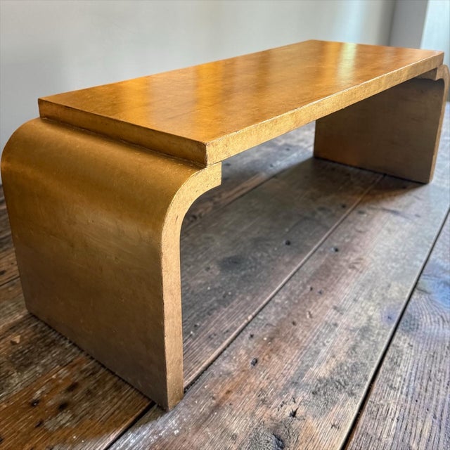 This is a late 20th century waterfall coffee table with a professionally applied gold leaf finish attributed to Dennis and...